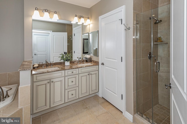 bathroom featuring double vanity, a stall shower, and a sink