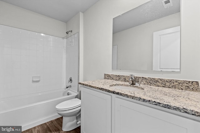 full bathroom with vanity, hardwood / wood-style floors, toilet, and tiled shower / bath