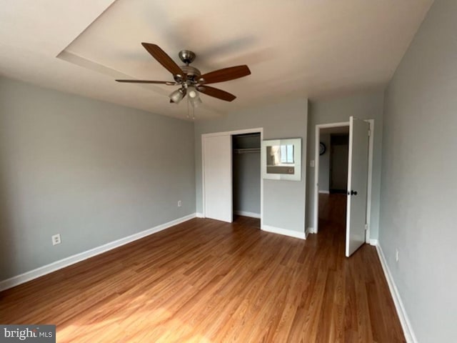 unfurnished bedroom with a closet, ceiling fan, and hardwood / wood-style flooring