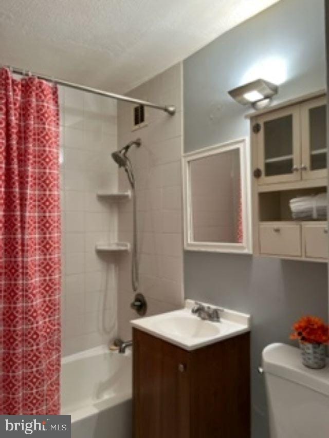 full bathroom featuring shower / tub combo, vanity, and toilet