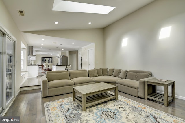 living room featuring vaulted ceiling and hardwood / wood-style floors