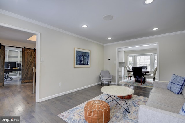 living room with dark hardwood / wood-style floors, ornamental molding, and a barn door