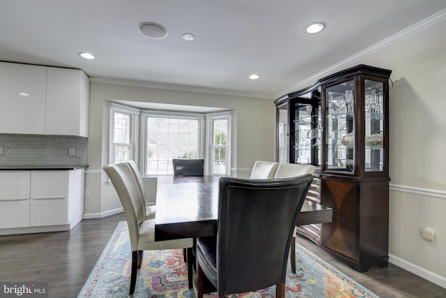 dining area featuring ornamental molding and dark hardwood / wood-style floors