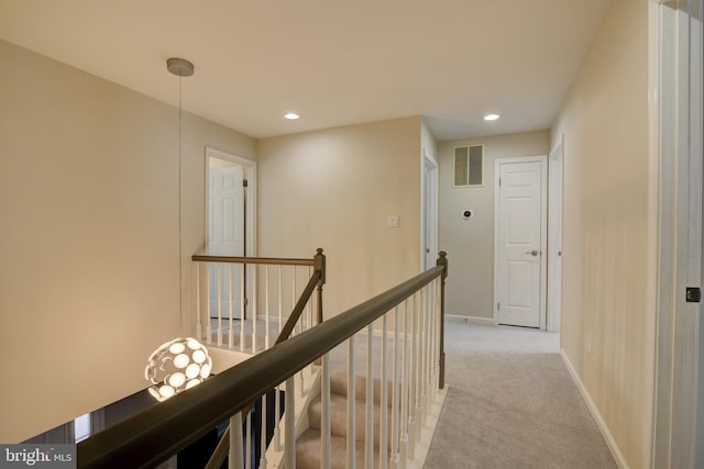 hallway featuring light colored carpet