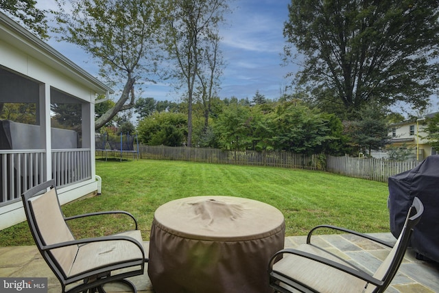 view of yard featuring a patio, a sunroom, and a trampoline