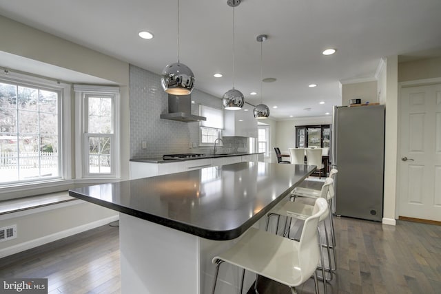 kitchen with a healthy amount of sunlight, decorative light fixtures, white cabinets, and appliances with stainless steel finishes