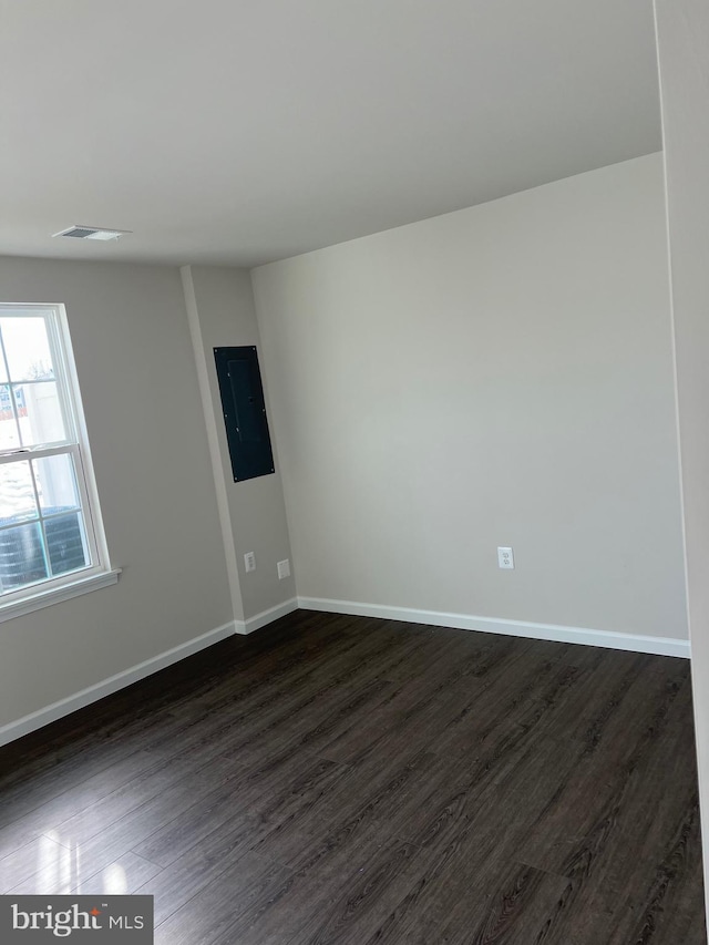 unfurnished room with dark wood-type flooring