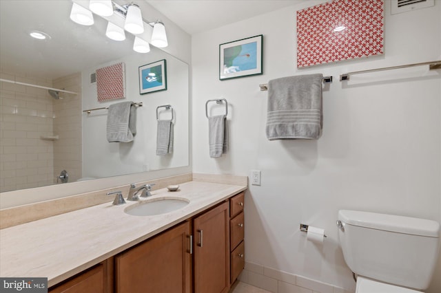 bathroom featuring vanity, toilet, and tiled shower