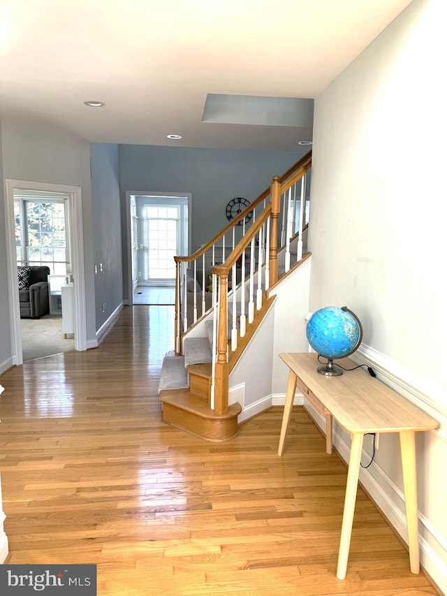 stairs with hardwood / wood-style flooring and a wealth of natural light