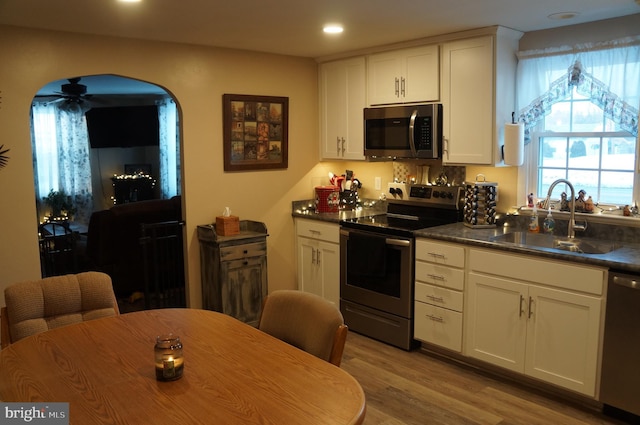 kitchen featuring appliances with stainless steel finishes, sink, white cabinets, and light hardwood / wood-style flooring