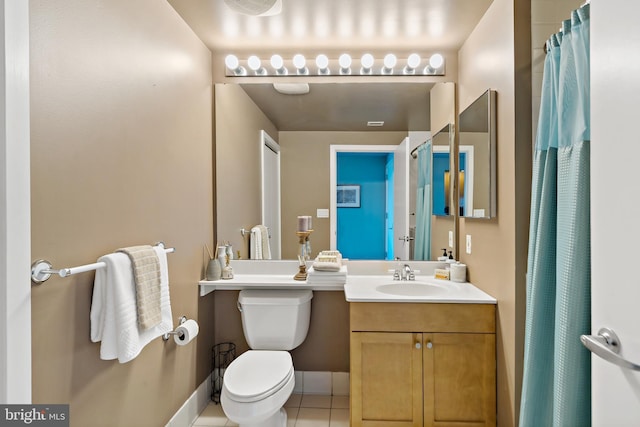 bathroom with toilet, vanity, baseboards, and tile patterned floors