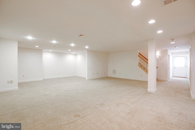 basement featuring recessed lighting, baseboards, light colored carpet, and stairway