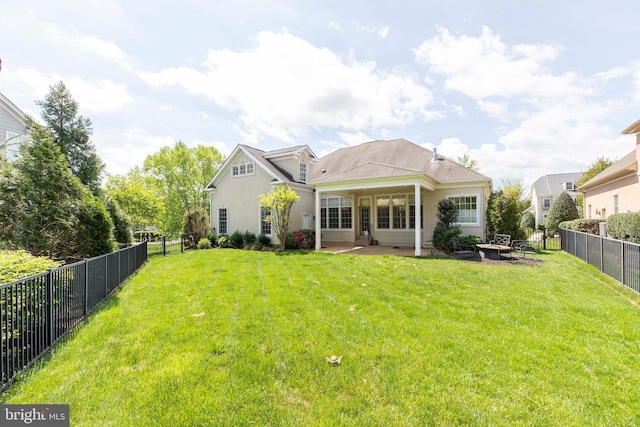 rear view of property featuring a fenced backyard, a patio area, stucco siding, and a yard