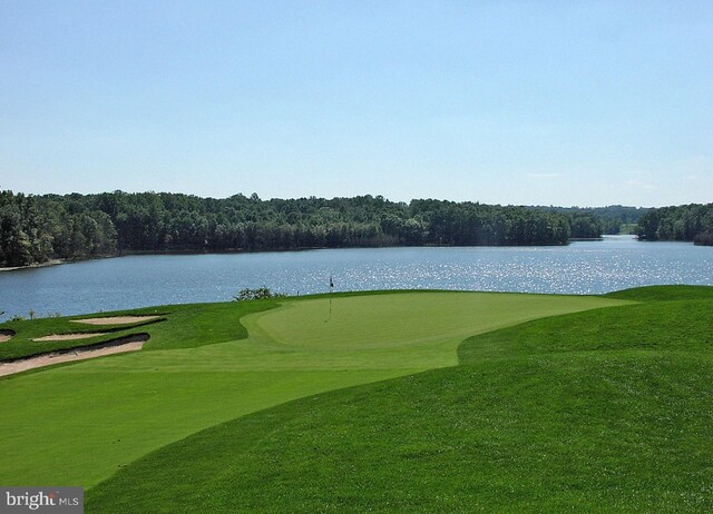view of home's community featuring a water view, view of golf course, and a forest view