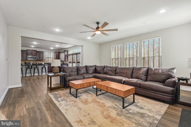 living room with recessed lighting, dark wood-style floors, and baseboards