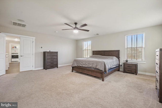 bedroom featuring visible vents, light carpet, and multiple windows