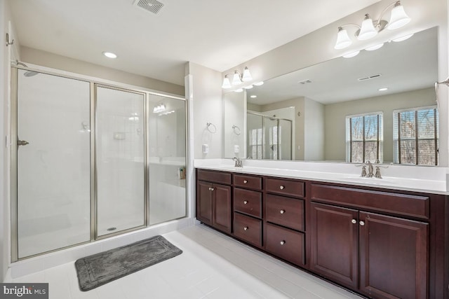 bathroom featuring a sink, double vanity, visible vents, and a stall shower