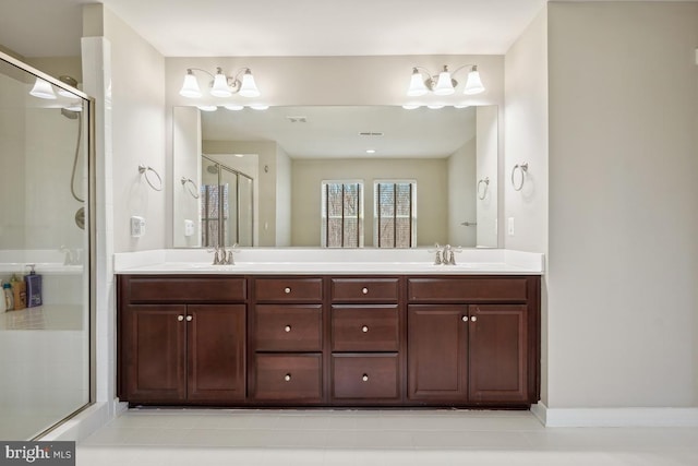 bathroom with a sink, a stall shower, and double vanity