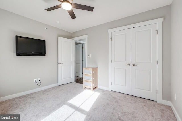 unfurnished bedroom featuring a closet, baseboards, carpet, and a ceiling fan