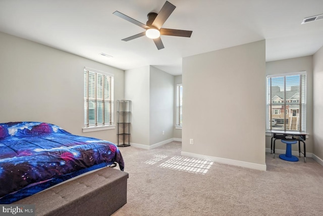 bedroom featuring multiple windows, visible vents, and light carpet