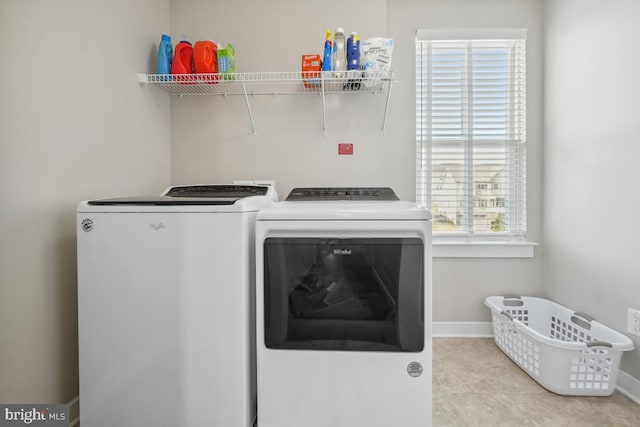 washroom featuring laundry area, baseboards, and washing machine and clothes dryer