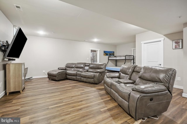 living area with recessed lighting, visible vents, baseboards, and light wood finished floors