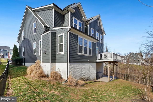 view of home's exterior with a deck, a residential view, a yard, and fence