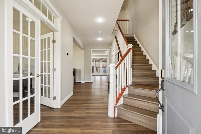 entryway with french doors, baseboards, dark wood-type flooring, and stairway