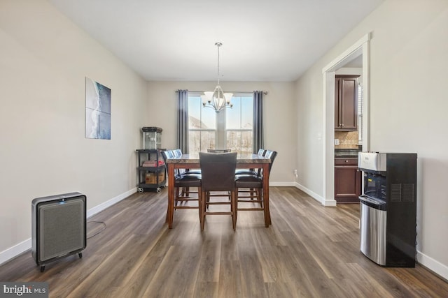 dining room featuring baseboards, dark wood-type flooring, and an inviting chandelier