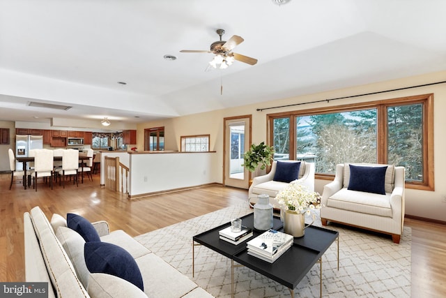 living room featuring baseboards, ceiling fan, visible vents, and light wood finished floors