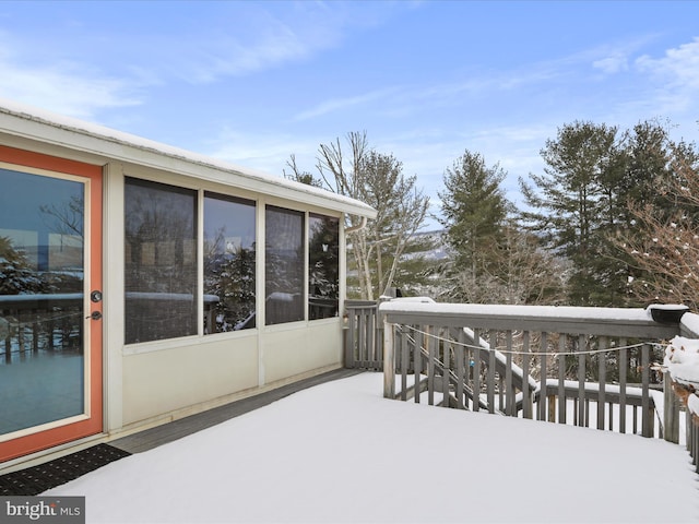 snow covered deck featuring a sunroom