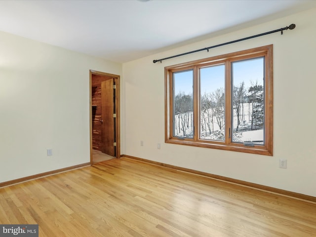 unfurnished room with baseboards and light wood-style floors