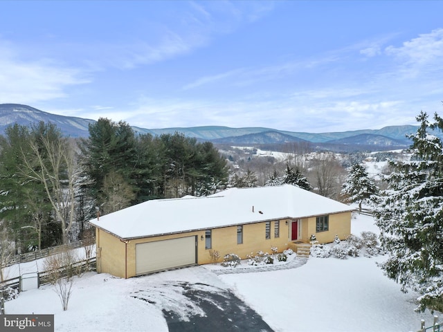 view of front of house with a garage, fence, and a mountain view