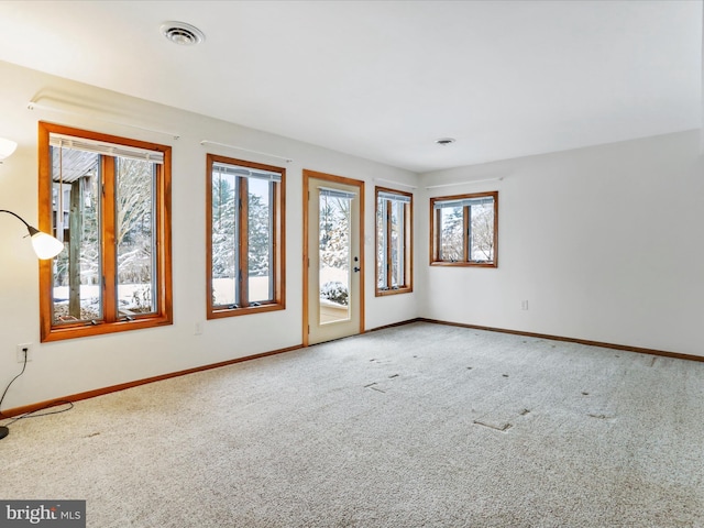 carpeted empty room featuring baseboards and visible vents