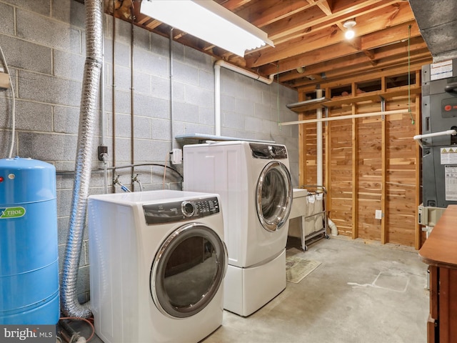 laundry room with laundry area, concrete block wall, and washer and dryer