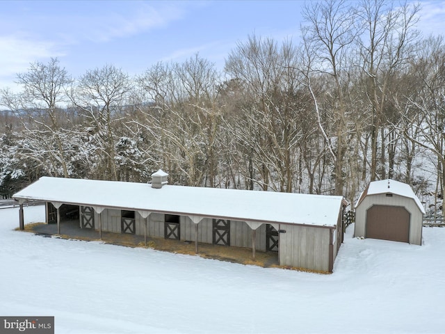 exterior space with a garage and an outbuilding