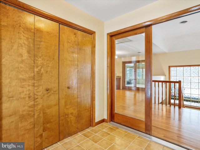 corridor featuring light tile patterned floors and visible vents