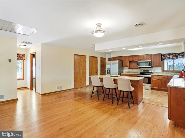 kitchen featuring appliances with stainless steel finishes, light wood-type flooring, and visible vents