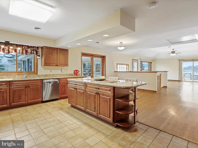 kitchen with light stone counters, open shelves, visible vents, a sink, and dishwasher