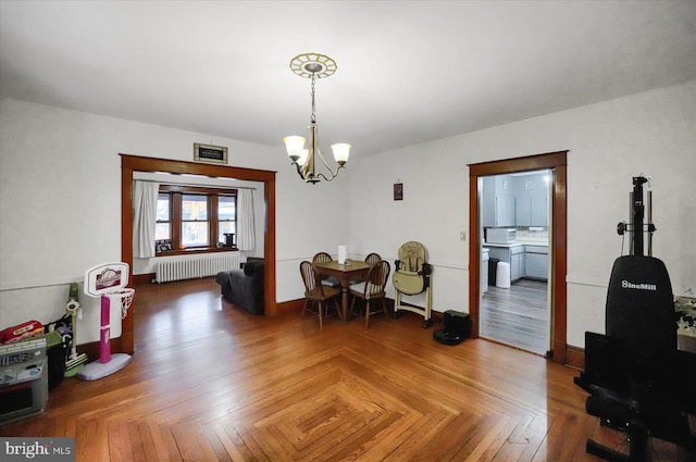 dining space featuring radiator heating unit, a notable chandelier, and parquet floors