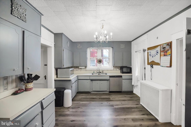 kitchen with sink, dishwasher, gray cabinetry, hanging light fixtures, and dark hardwood / wood-style flooring