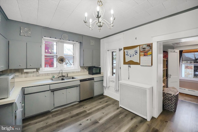 kitchen featuring radiator, sink, gray cabinetry, stainless steel appliances, and dark wood-type flooring