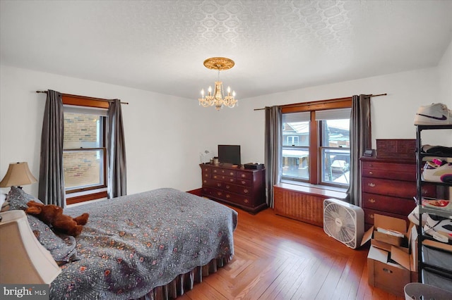 bedroom with parquet floors, a textured ceiling, and a chandelier