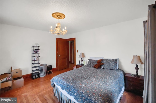 bedroom featuring an inviting chandelier and parquet flooring