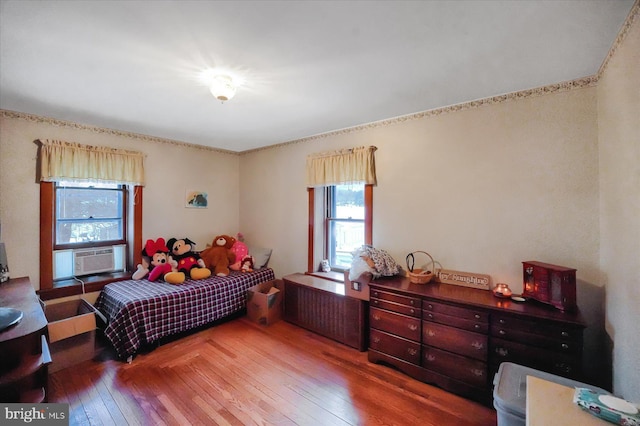 bedroom with cooling unit and hardwood / wood-style floors