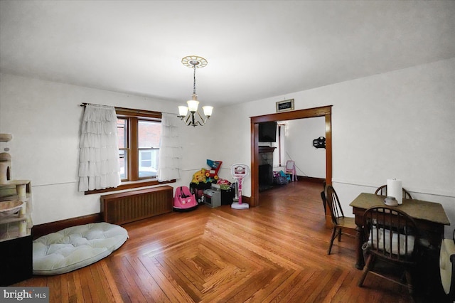 dining area featuring an inviting chandelier, radiator heating unit, and parquet flooring