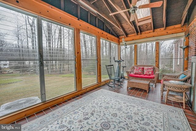 sunroom / solarium with ceiling fan and lofted ceiling with skylight