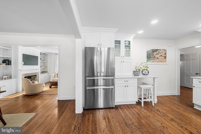 kitchen featuring built in shelves, dark wood-type flooring, white cabinetry, ornamental molding, and stainless steel fridge