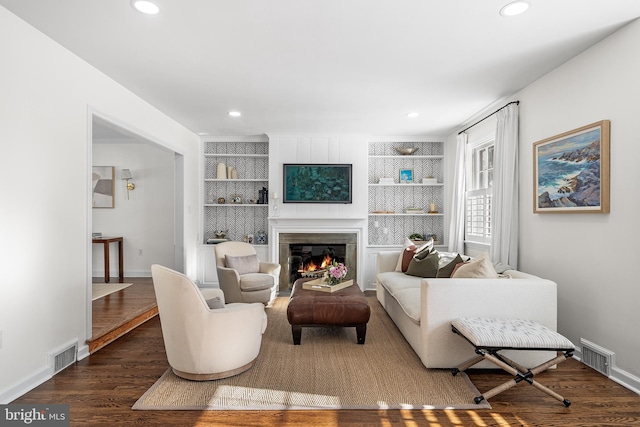 living room with dark wood-type flooring and built in shelves