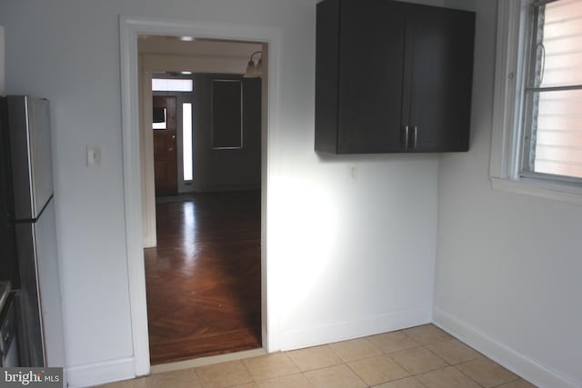 interior space featuring light tile patterned floors and refrigerator